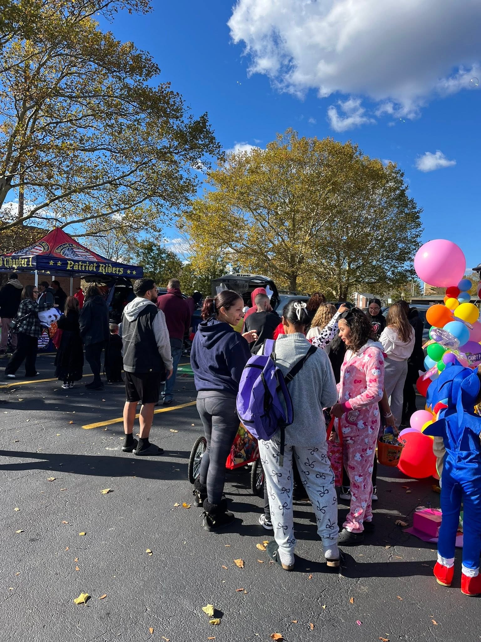 Children in costumes with colorful balloons at the Hearts with Hope Trunk or Treat